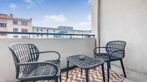 2 chaises et une table sur un balcon dans l'établissement Homey Coloc Dolce - Proche gare et tram, Balcon, Wifi, à Ambilly