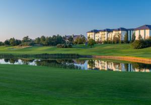 einen Golfplatz mit einer Spiegelung eines Gebäudes in der Unterkunft The Heritage in Killenard