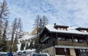 ein Gebäude mit Schnee auf dem Dach mit einem Berg in der Unterkunft Splendida Carezza in Karersee