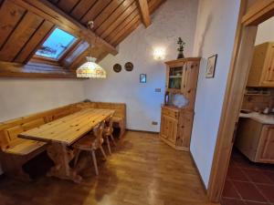 ein Esszimmer mit einem Holztisch und einer Küche in der Unterkunft Splendida Carezza in Karersee