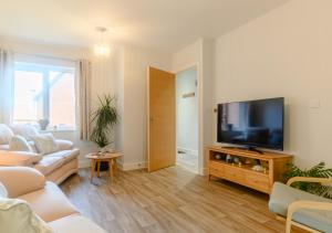 a living room with a couch and a flat screen tv at Walkers Rest in Sheringham