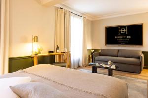 a hotel room with a bed and a couch at Hostellerie Briqueterie & Spa Champagne in Vinay