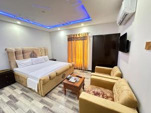 a hotel room with a bed and a couch at Decent Lodge Guest House in Islamabad