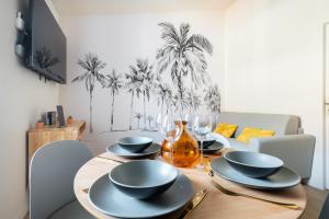a dining room table with plates and wine glasses at Olivier * Cosy * Linge hôtelier * Fibre * Calme in La Destrousse