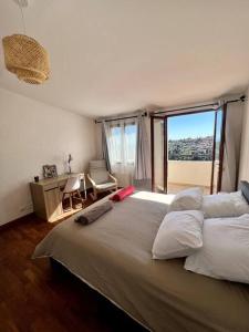 a bedroom with a large bed with a large window at Charmante maison de village in Falicon