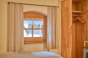 a bedroom with a window with curtains and a bed at Alte Schmiede in Balderschwang