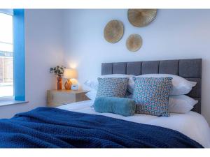 a bedroom with a bed with blue sheets and pillows at Churchside Apartments in Eccles near Trafford and Salford in Manchester