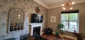 a living room with a fireplace and a tv on the wall at *Leamington Apartments* - Avenue Road - 1 bedroom apartment in Leamington Spa