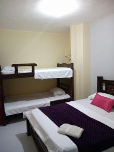 sypialnia z 2 łóżkami piętrowymi i fioletowym kocem w obiekcie RUTA DEL MAR INN HOTEL w mieście Santa Marta