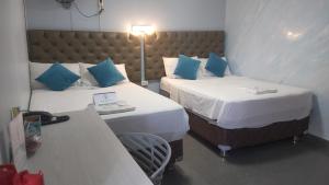 een kamer met 2 bedden en een bureau met een laptop bij Hotel Jose Ignacio Chepen in Chepén