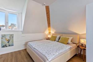 ein Schlafzimmer mit einem Bett und zwei Fenstern in der Unterkunft Charmante Dachgeschosswohnung mit Balkon in Bruckmühl