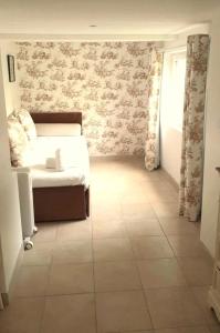 ein Schlafzimmer mit einem Bett und einem gefliesten Boden in der Unterkunft La Maison de la toile de Jouy in Jouy-en-Josas