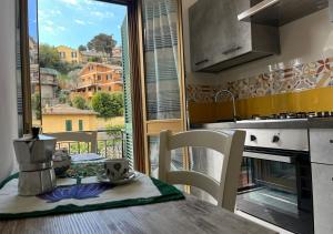 uma cozinha com uma mesa e vista para uma varanda em Casa degli Ulivi em Porto Santo Stefano