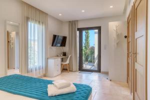 a bedroom with a bed and a desk and a television at Akwabay - Les Villas du Cap in Le Lavandou
