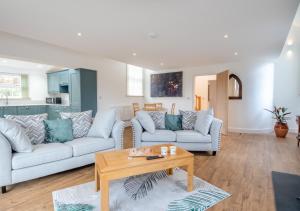 a living room with two couches and a table at The Old Chapel - Tasburgh in Ashwellthorpe