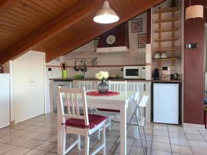 una cucina con tavolo e sedie bianchi di Terrazza sul Mare a SantʼElpidio a Mare