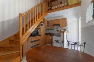 a kitchen with a wooden table and a wooden staircase at Gite 1 entre 4 et 6 personnes in Reynès