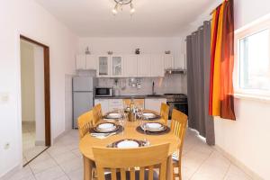 a dining room with a table and chairs in a kitchen at Kuća za odmor Pixie in Vrsi