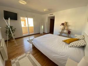 - une chambre avec un grand lit blanc et du parquet dans l'établissement Villa Benidorm Levante Beach, à Benidorm