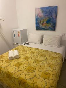 1 dormitorio con 1 cama con 2 toallas en Hotel Pousada Iracemar - Guarujá, en Guarujá