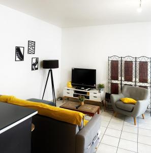a living room with a couch and a tv at Nice flat close to Stade de France & Paris' heart in Saint-Denis