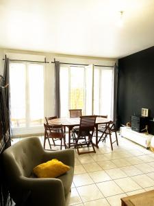 a living room with a couch and a table and chairs at Nice flat close to Stade de France & Paris' heart in Saint-Denis