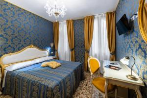 ヴェネツィアにあるホテル イル メルカンテ ディ ベネツィアのベッドルーム1室(ベッド1台、テーブル、デスク付)