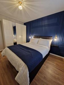 a bedroom with a large bed with a blue wall at Impeccable 2-Bed Apartment in Newcastle upon Tyne in Newcastle upon Tyne