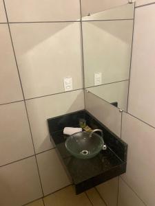 y baño con lavabo y espejo. en Hotel Iracemar - Piscina Aquecida en Guarujá