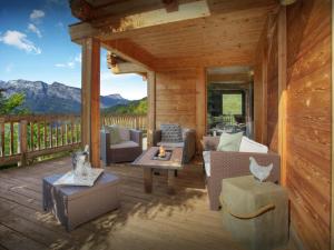 a porch of a cabin with couches and a table at Chalet Parakima - OVO Network in Manigod