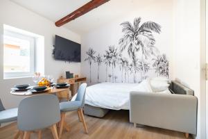 a bedroom with a bed with a palm tree mural at Olivier * Cosy * Linge hôtelier * Fibre * Calme in La Destrousse