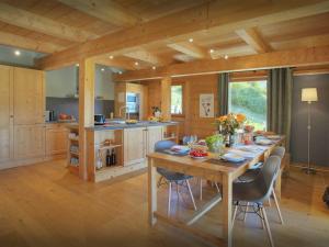 a large kitchen with a wooden table and chairs at Chalet Parakima - OVO Network in Manigod