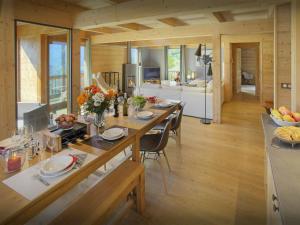 a kitchen and dining room with a long wooden table at Chalet Parakima - OVO Network in Manigod