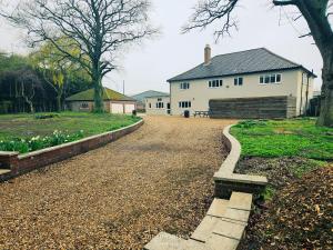 a driveway leading to a white house with a barn at The Plough Inn Farmhouse - Private Holiday House in Lenwade