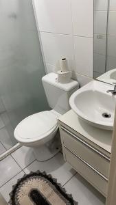 a white bathroom with a toilet and a sink at Park marilandia 507 in Juiz de Fora