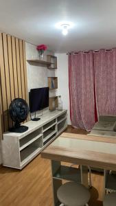 a living room with a desk with a television and a deskablish at Park marilandia 507 in Juiz de Fora