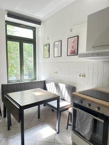 Il comprend une cuisine équipée d'une table et d'une cuisinière. dans l'établissement Apartment Arenablick, à Leipzig