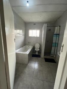 a bathroom with a bath tub and a toilet at Golden bamboo in Nyanda