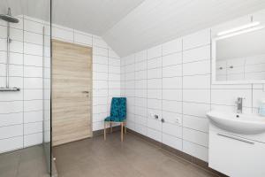 霍尔特Guesthouse Rauðafell的一间带水槽和蓝色椅子的浴室