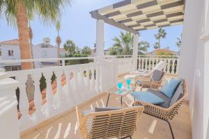 a patio with chairs and tables on a balcony at Villa YOLO in Peyia