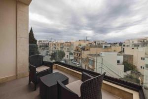 a balcony with chairs and a view of a city at Luxurious in Is-Swieqi