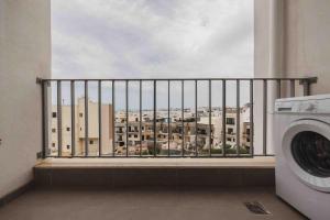 a view of a city from a balcony with a washing machine at Luxurious in Is-Swieqi