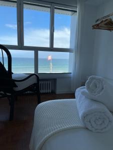 a bedroom with a bed and a view of the ocean at Boogalow Hostel in Gijón