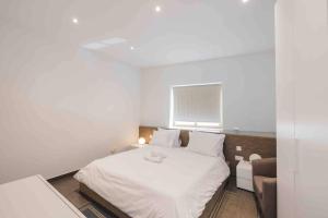 a bedroom with a white bed and a window at Hidden Gem in Sliema
