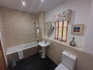 a bathroom with a toilet and a sink and a tub at Arden Country House in Linlithgow