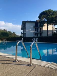 a swimming pool with two metal bars in front of a building at Cosy in the Park quiete e relax in un'oasi verde in Como