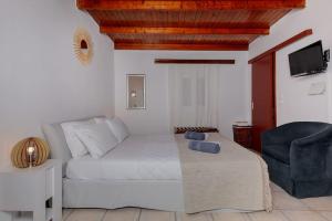 a living room with a bed and a chair at Spot on the sea in Archangelos