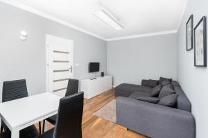 sala de estar con sofá y mesa en Osiedle Avia Modern Apartment, en Cracovia