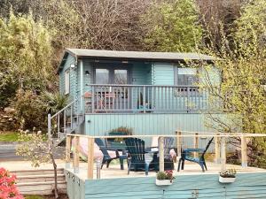 a blue house with a table and chairs on a deck at Mountainside Cabin in Newcastle