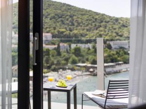 a balcony with a table and two glasses of wine at Hotel Kompas in Dubrovnik